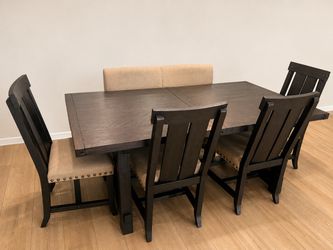 Farmhouse style black wooden dining table, chairs, and console table