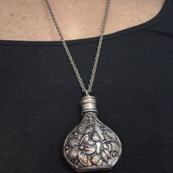 Silver perfume bottle necklace with floral design