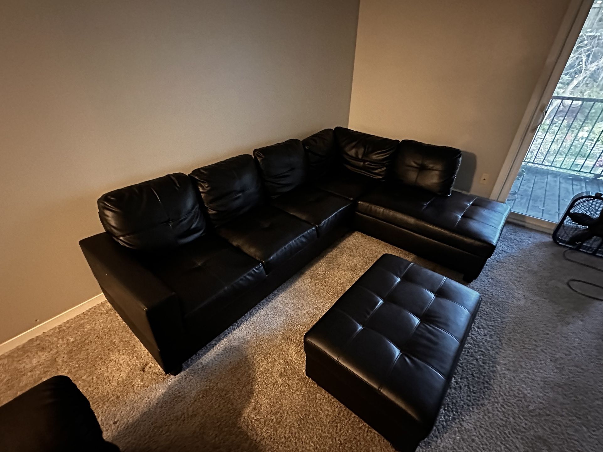black leather L shaped couch with ottoman
