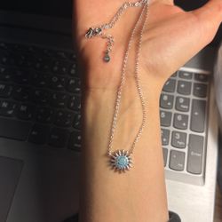 A 925 sterling silver necklace with a unique sun design and a blue center