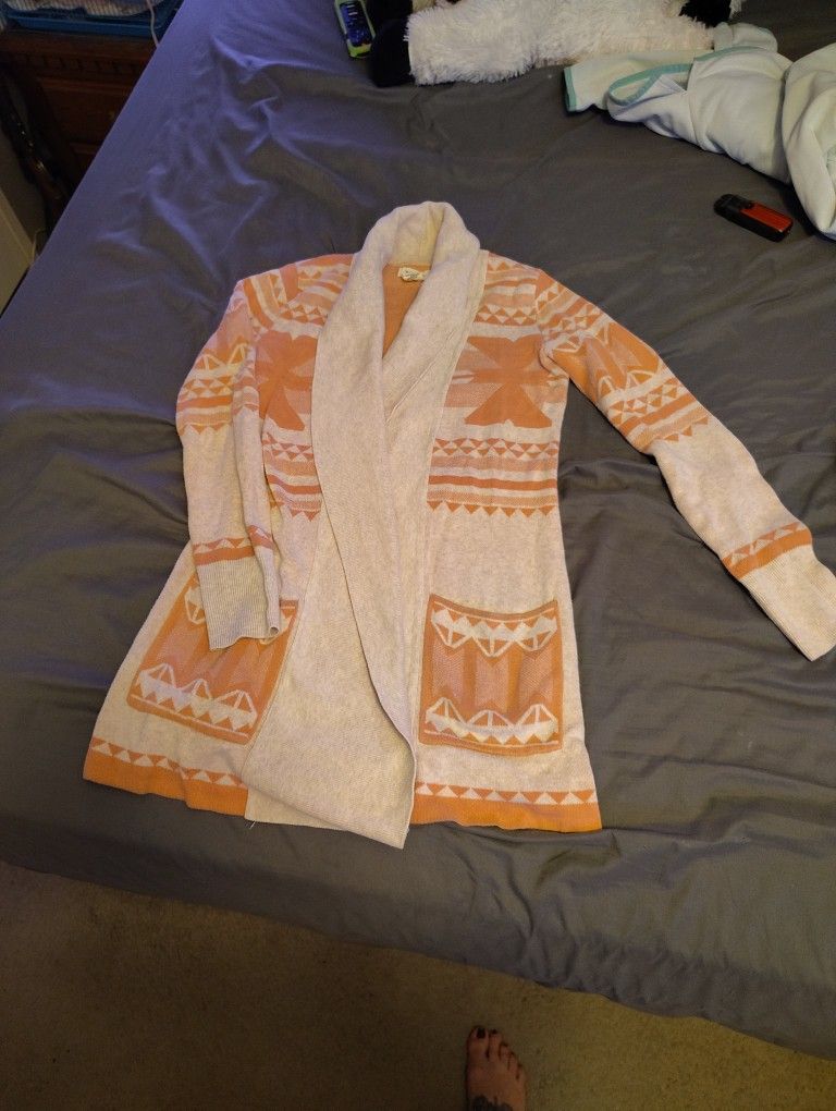 women's orangish/Pinkish and grey Aztec or geometric patterned open-front cardigan.