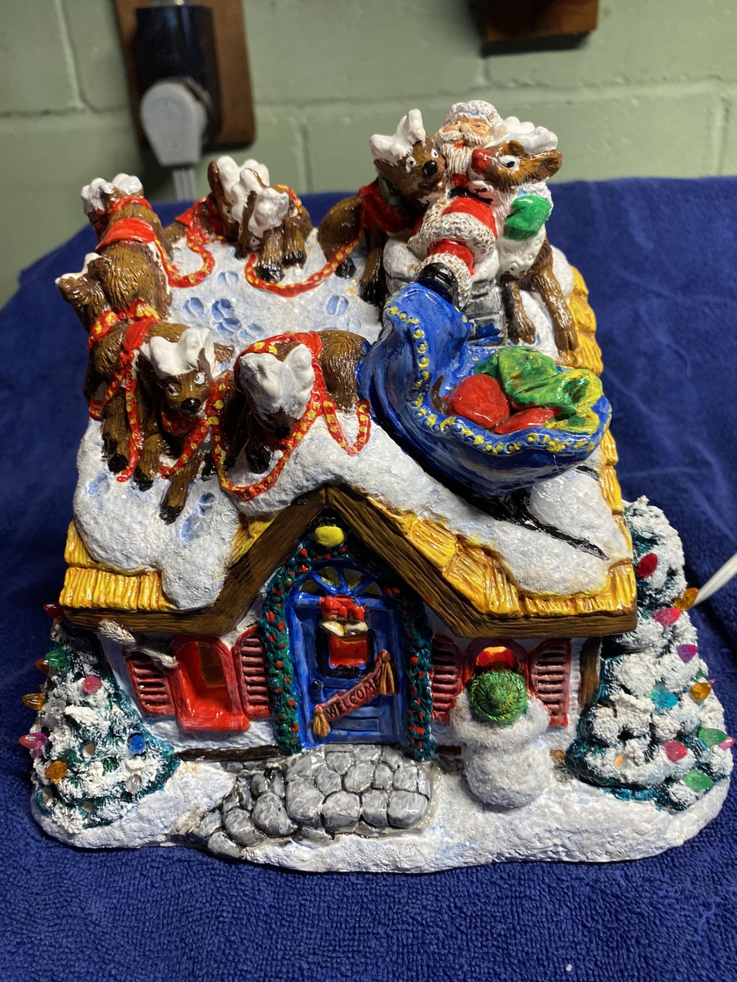 Christmas House Decorated With Santa And Reindeer On The Roof
