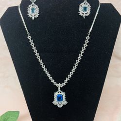 silver-plated jewelry set includes a necklace and matching dangle earrings featuring blue cubic A a