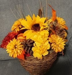 Fall flowers in a wicker basket nice to hang on a door or just set out.