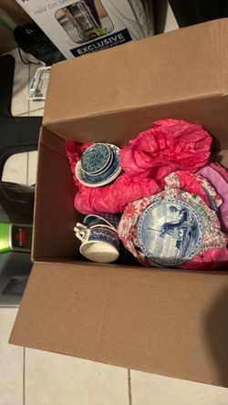 box  full of vintage while and blue cups plates and some nick nacks