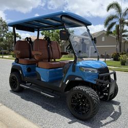 Fully loaded, lifted golf cart with four forward-facing seats.