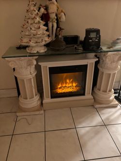 Electrical fireplace gives out heat and has glass top mantle table ..52” wide, 16” depth, 30” high . $150