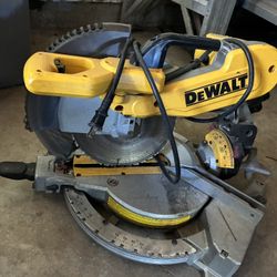AI Overview    +2 This is a DeWalt compound miter saw, likely a 12-inch sliding model such as the DWS780 or DWS779.  Features a yellow body with black