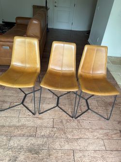 Stylish West Elm dining chairs in camel/cognac vegan leather