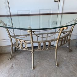 30 Inches Tall By 57 Inches Wide, Curved Thick Glass Table W/ Waterfall Edge Trim & Hardwood Frame In Metal Two Tone Frame. Carved Details.