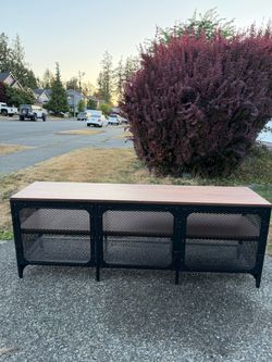 Beautiful large industrial-style media console featuring a wood-look top, black metal frame, and mesh cabinet doors.