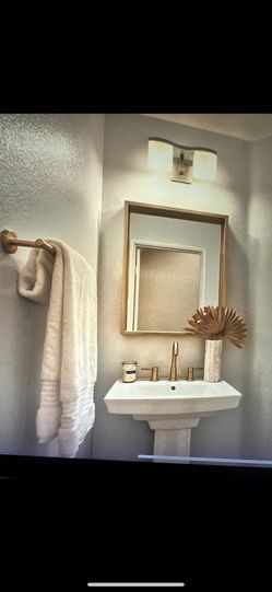 Gold Faucet Bathroom With A Matching Mirror
