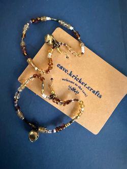 Adorable Kitty Cat Shaped Handmade Beaded Earrings with a Bell at the “neck collar”   Handmade beaded earrings feature a mix of brown, amber, white, a