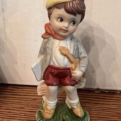 Vintage  figurine depicting a young boy playing the violin