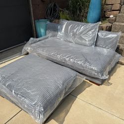 New beautiful gray corduroy armless couch, and a huge ottoman. 