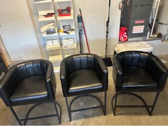 Three black bar stool chairs