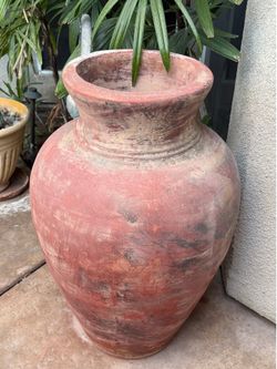 Large, rustic, weathered terracotta jar resembling an antique olive oil or wine amphora.