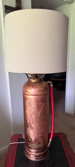 Copper fire extinguisher converted into a table lamp, has 3 way switch
