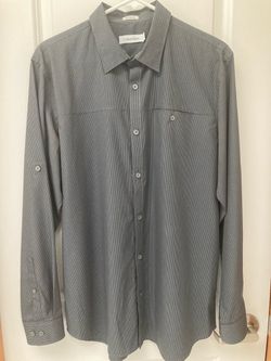 Brand New! Calvin Klein long-sleeve button-down dress shirt with a spread collar, chest pocket, and button cuffs. Men size Medium.
