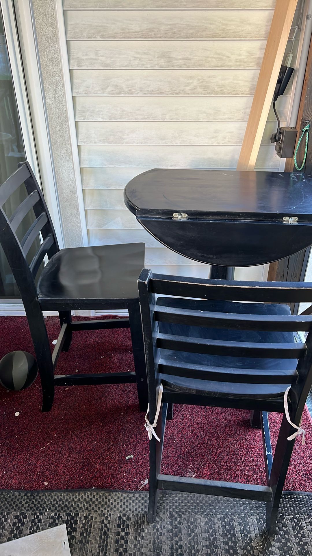 This is a black round drop-leaf dining table.  