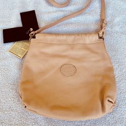 Roots Genuine Leather Mini Drawstring Crossbody Bag in Blush, in like new preowned condition. Original tags attached. Adjustable shoulder strap