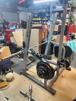 Nautilus home gym half squat rack and pull down cables with 275lbs of weights, Olympic bar, curl bar and more