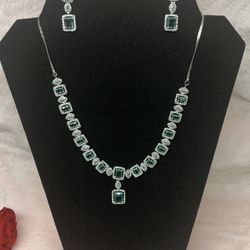 green American diamond necklace set featuring emerald-colored stones and silver plating. 