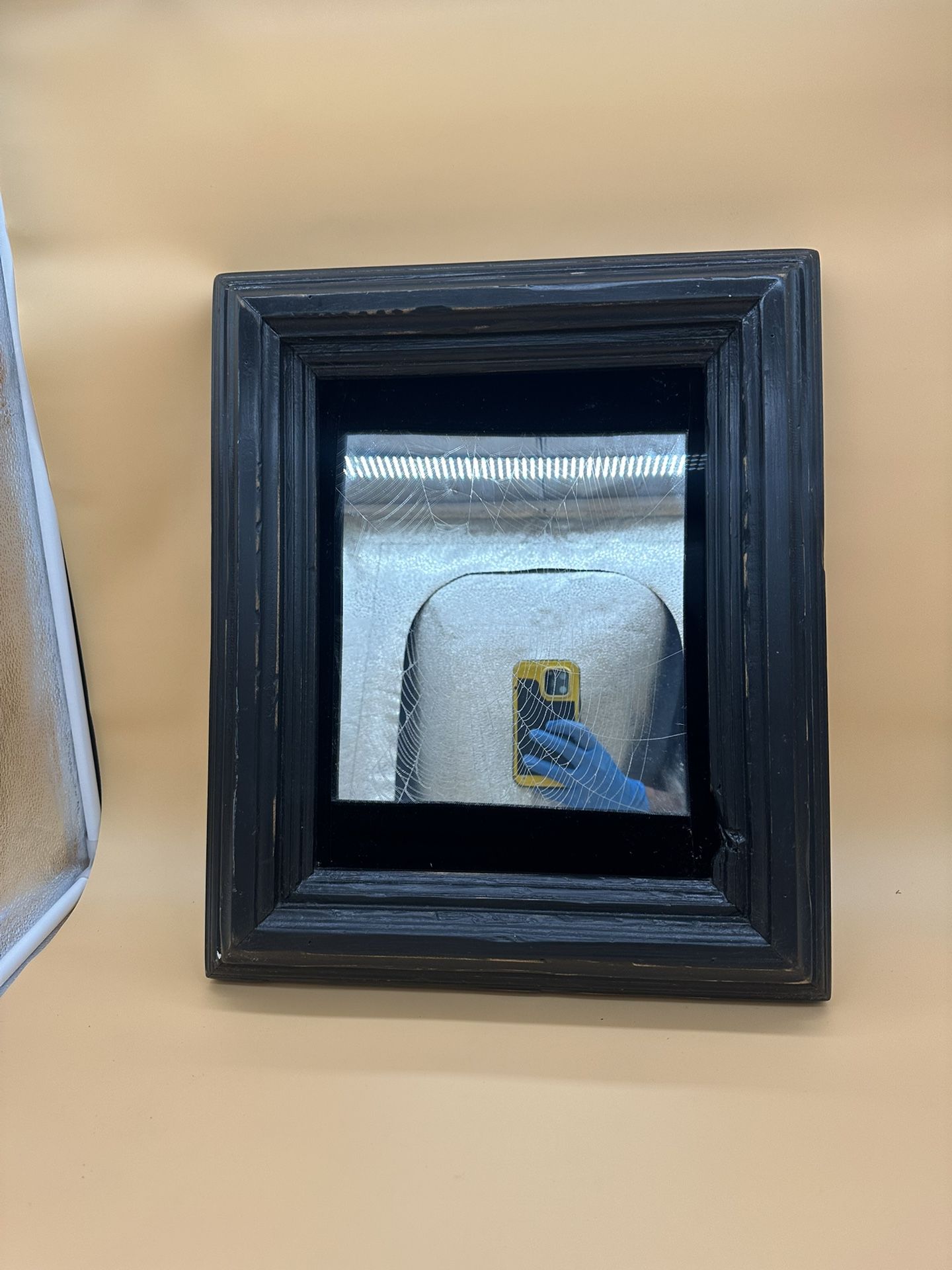 antique mirror in a brutal wooden frame and glass with a spider web engraving