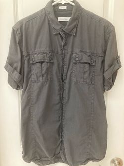Brand New! Calvin Klein short-sleeve button-down dress shirt in gray with a point collar, dual chest pockets with button flaps, and rolled sleeves. Me