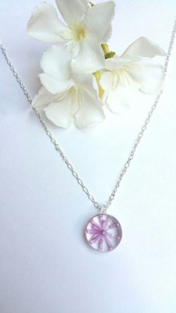 Necklace with handblown round glass pendant with painted pink flower on a silver colored chain