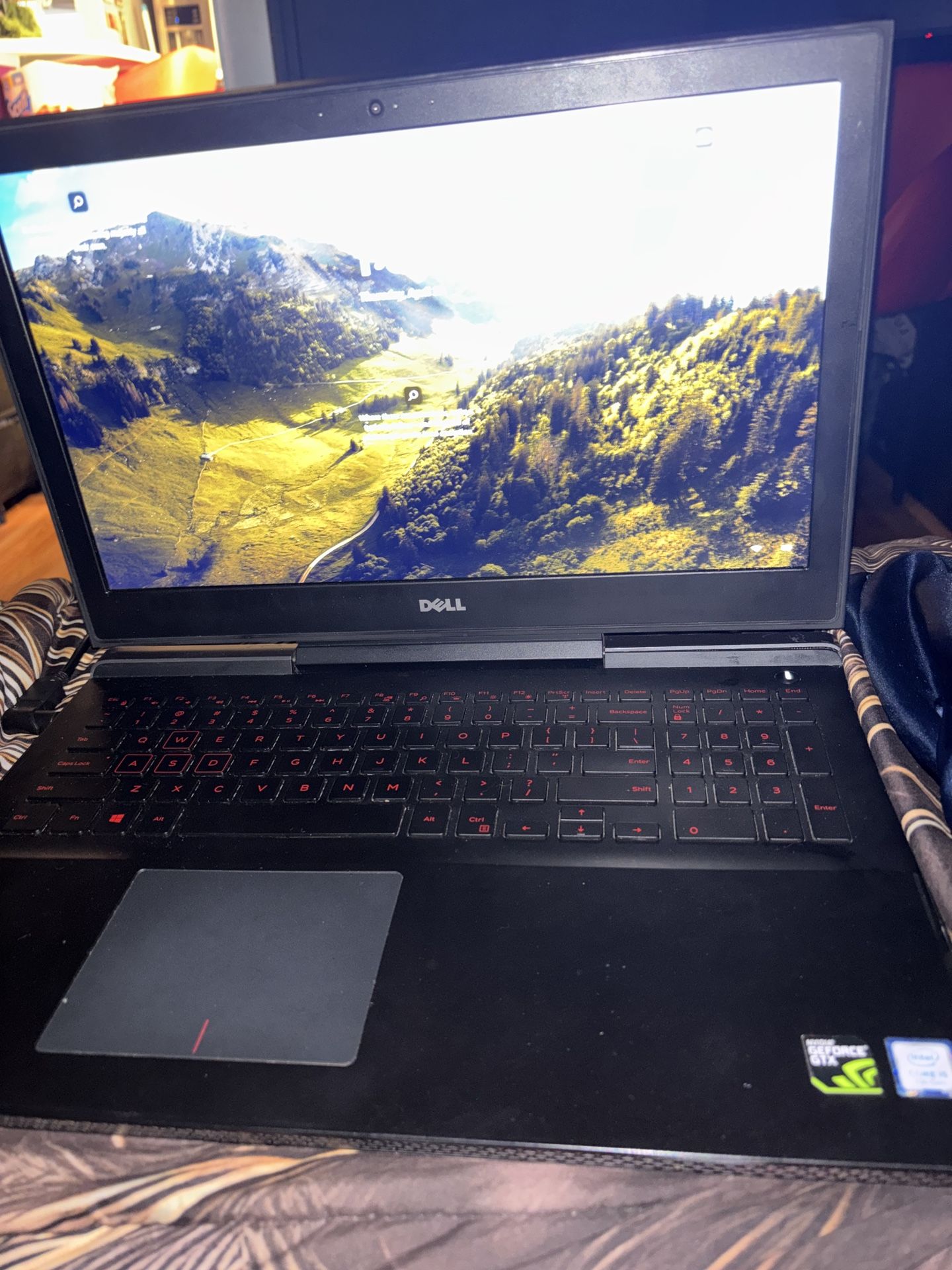 Dell Inspiron 15 7567 gaming laptop featuring red keyboard backlighting and a NVIDIA GeForce GTX graphics card.