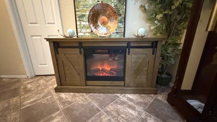 Beautiful rustic fireplace/tv stand in excellent condition with barn doors 60"