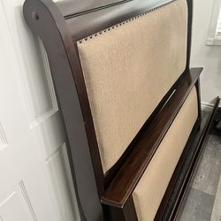 Queen size upholstered bed frame including headboard and footboard.