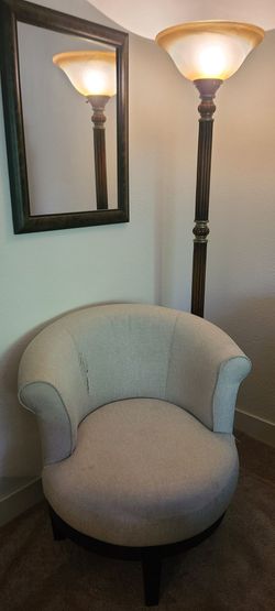 Cream colored swivel chair, lamp