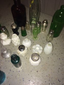 Assortment of antique salt and pepper shakers along with bottles and ink well