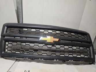 OEM black front grille with a hexagonal mesh pattern and a gold Chevrolet bowtie emblem for a 2014-2015
Chevrolet Silverado 1500