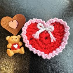 Valentine's Day-themed collectibles, including a red and pink crochet heart