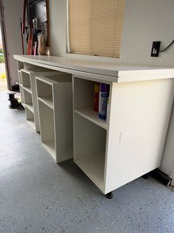 Two white table tops with shelving’s