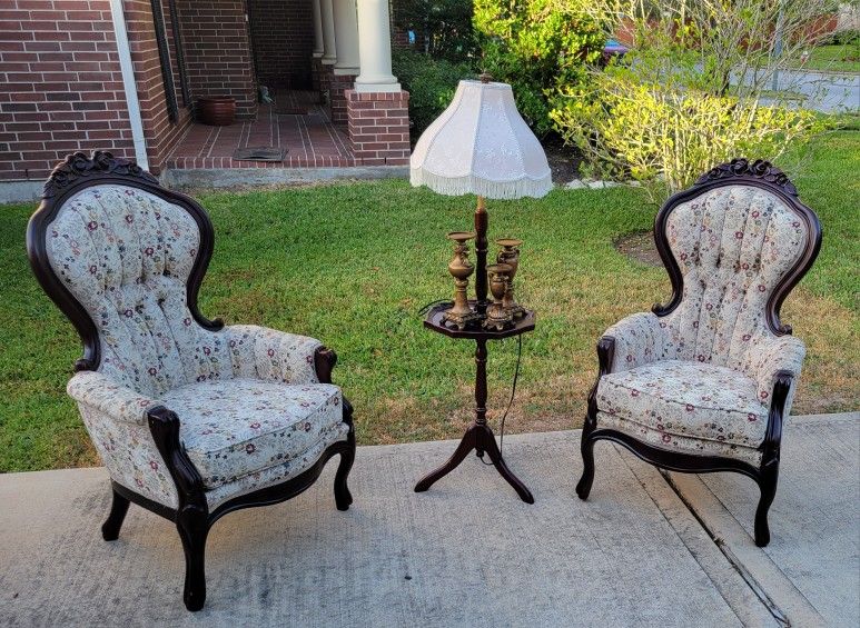 Pair of Vintage Victorian-style wingback armchair with a carved wood frame and floral-patterned upholstered cushions.