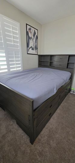 Full size bed frame with 8 drawers and book shelf head board.