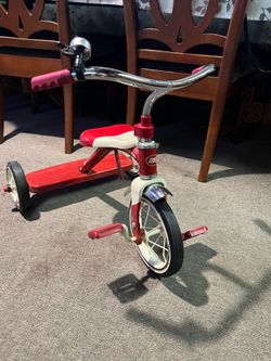The Radio Flyer Classic Red tricycle features a durable steel frame and chrome handlebars.