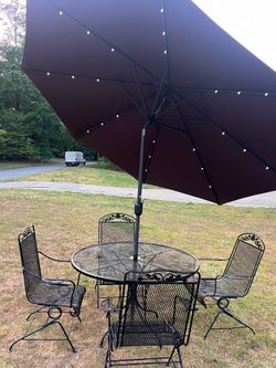 Outdoor table with four chairs, including umbrella