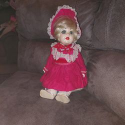 Antique  porcelain doll in red dress.