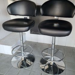 Set of 2 modern black faux-leather bar stools with polished chrome bases. Perfect for a kitchen island, home bar, or game room.