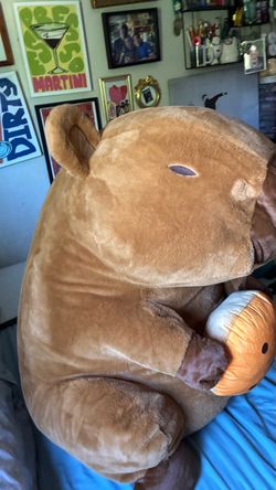 Giant capybara plushy holding a cookie