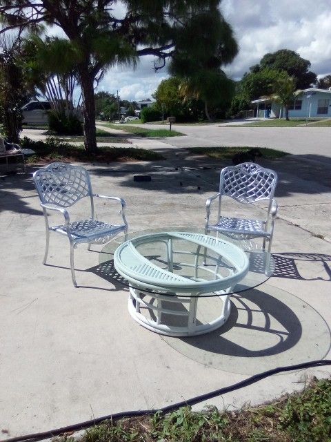 Out Door Wicker Glass Table Very Large For Our Side.or For Your Patio Pretty White ..Table Is Heave Will Not Blow Over ..Some Scratches On The Glass..