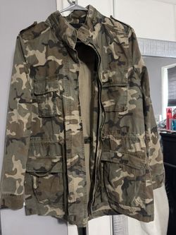 Green and brown camo jacket with zipper and button closure, multiple pockets, and adjustable waist