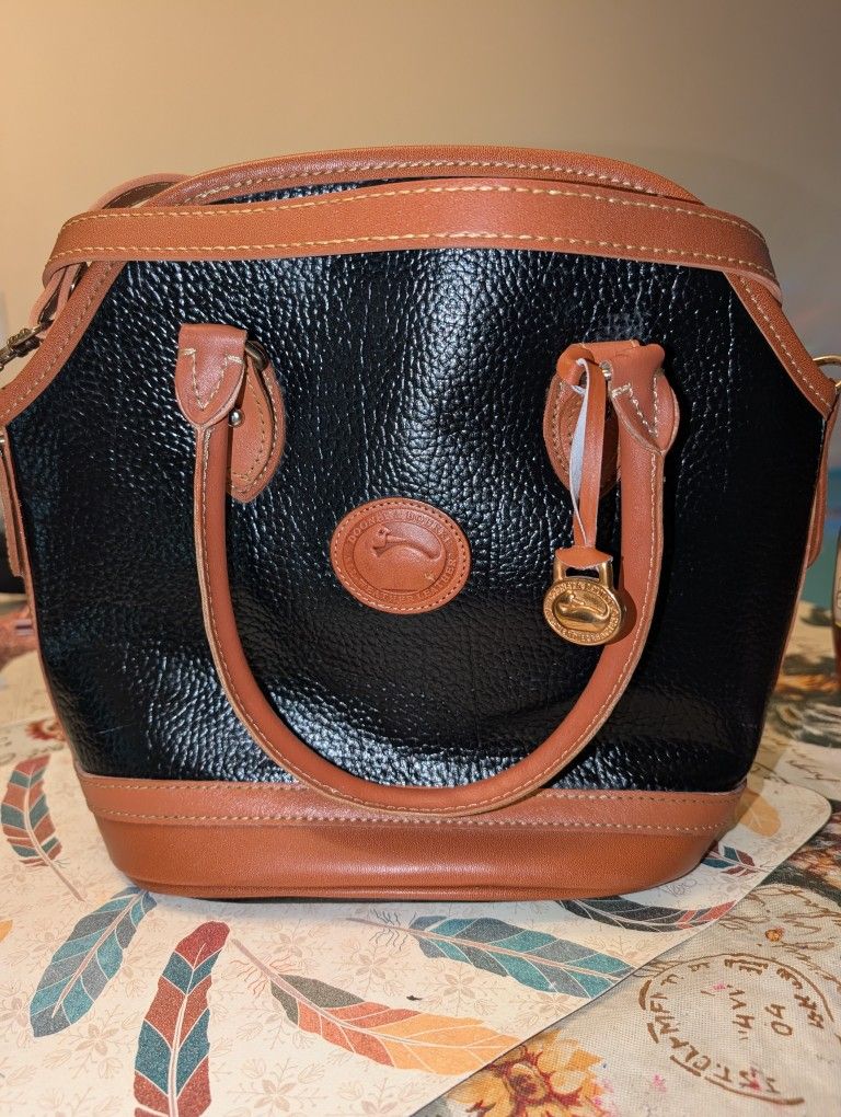 Vintage Dooney & Bourke All-Weather Leather Norfolk bag in black with British tan trim.