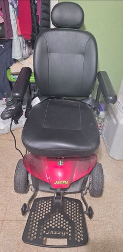 Pride Mobility Jazzy Elite ES portable power chair in red with a black vinyl seat.