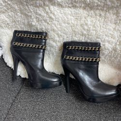 Tory Burch Lysa black leather ankle boots with gold-tone chain-link accents and a stiletto heel